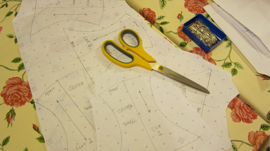 Cutting out pattern pieces from dot and cross pattern paper.