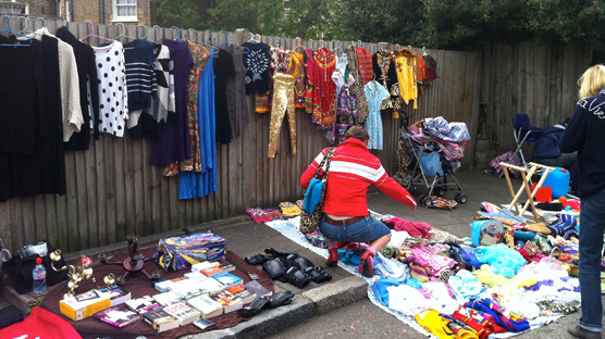 Fences lined with cute and colourful clothing & blankets piled high to rfile through.