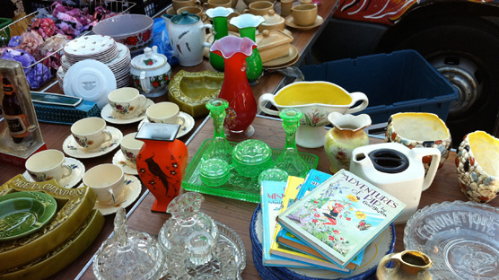 A table heaving with lovely bits of crockery, glassware & annuals.
